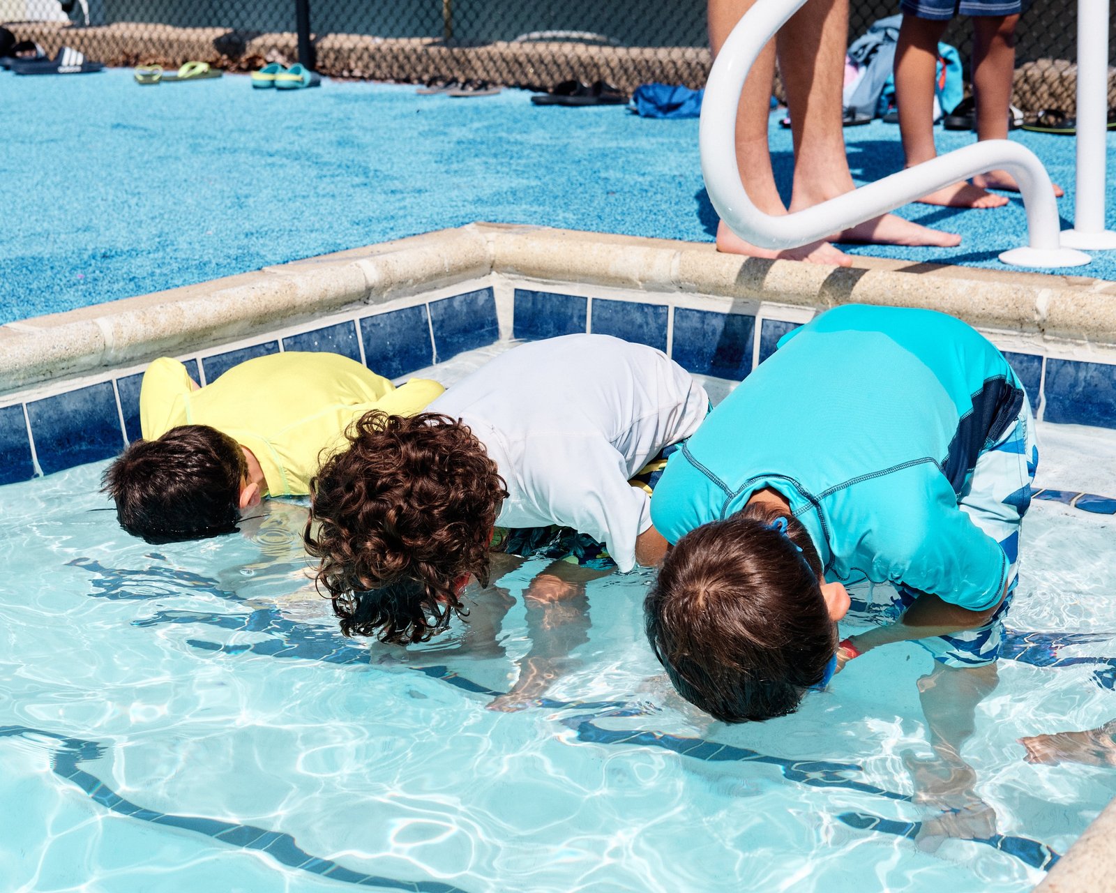 a group of children playing in a swimming pool